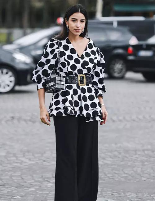 A model wearing a polka dot peplum top with relaxed pants