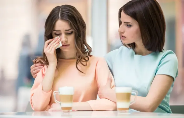 A woman consoling a sad friend
