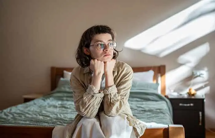 A woman sitting in her lonely bedroom