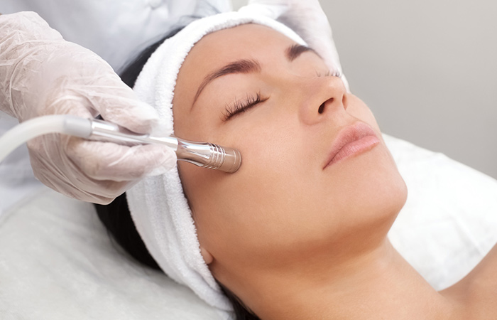 Cosmetologist performing microdermabrasion on a woman