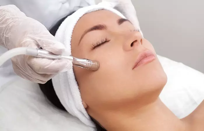 Cosmetologist performing microdermabrasion on a woman
