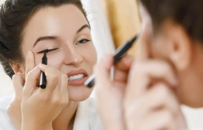 Pulling Eyes To Apply Eyeliner