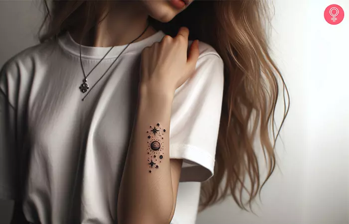 A woman with a minimalist space tattoo on her forearm