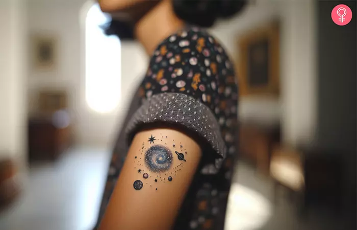 A woman with a realistic space tattoo design on her upper arm