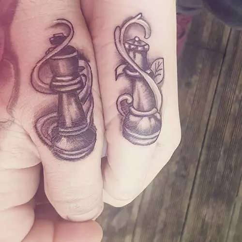 Chess icons for king and queen tattoos on thumbs