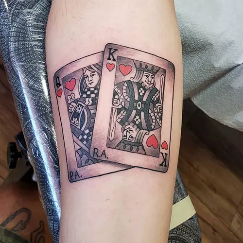 Card king and queen tattoos on the forearm