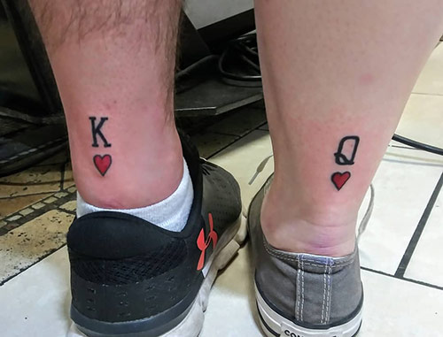 Letters k and q along with red hearts for king and queen tattoos on the backside of the ankle