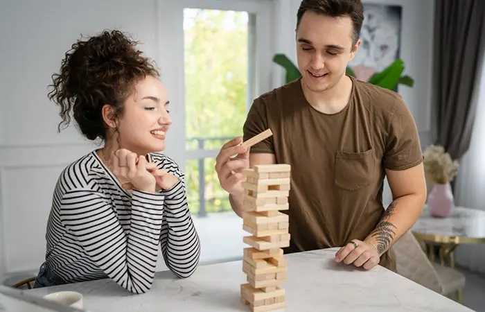 A couple playing jenga at home