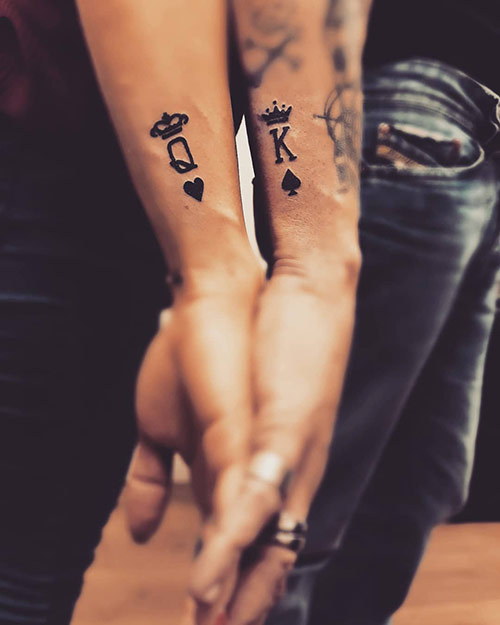 Letters k and q along with spade and heart depicting king and queen tattoos on the side of the wrists