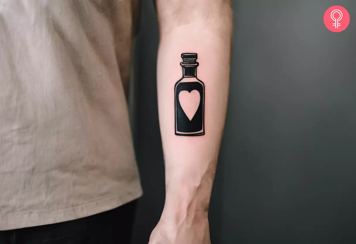 A black and gray tattoo on the arm featuring a potion bottle with a heart