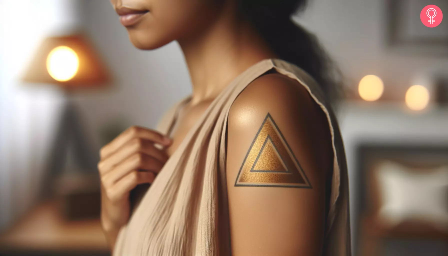 A woman with a golden triangle tattoo on her upper arm