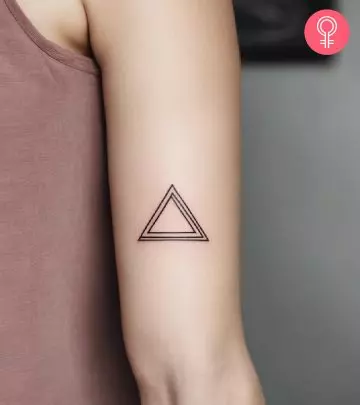 Woman with a pyramid tattoo on the upper arm