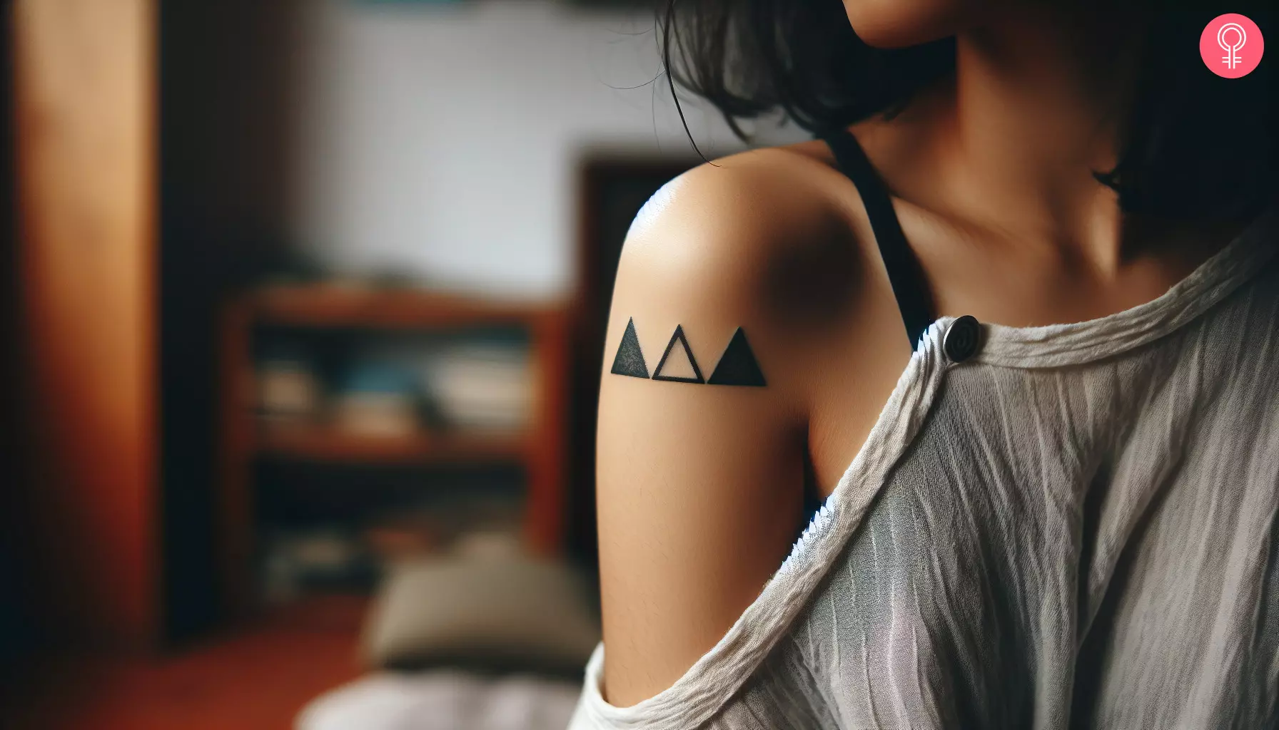 A woman with a past present future triangle tattoo on her upper arm