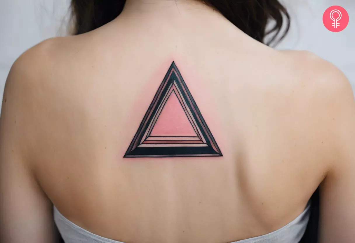 A woman with a pink triangle tattoo on her upper back