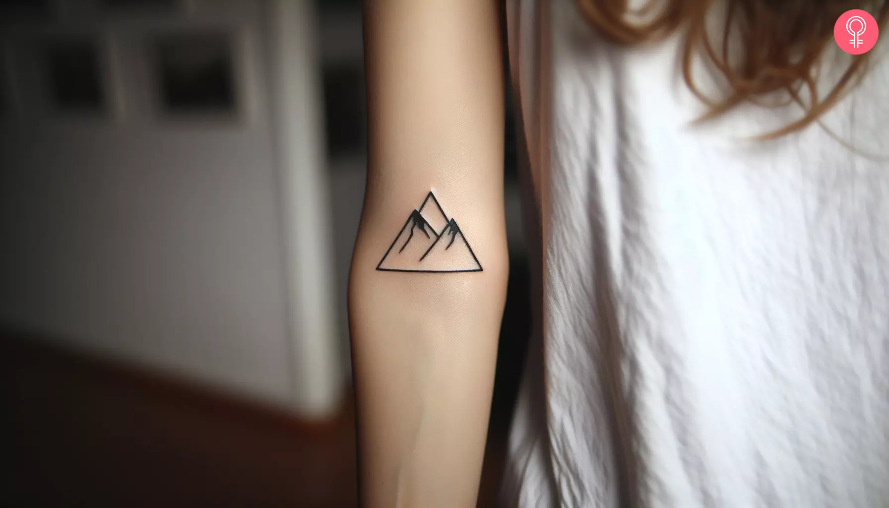 A woman with a simple triangle mountain tattoo on her arm
