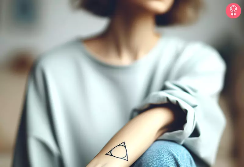 A woman with a sobriety triangle tattoo on her forearm