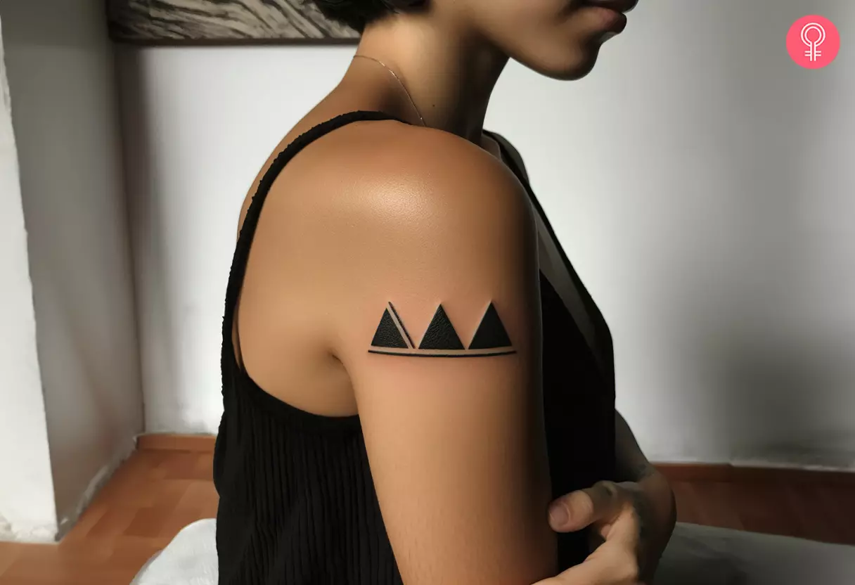 A woman with a three-triangle tattoo on her upper arm