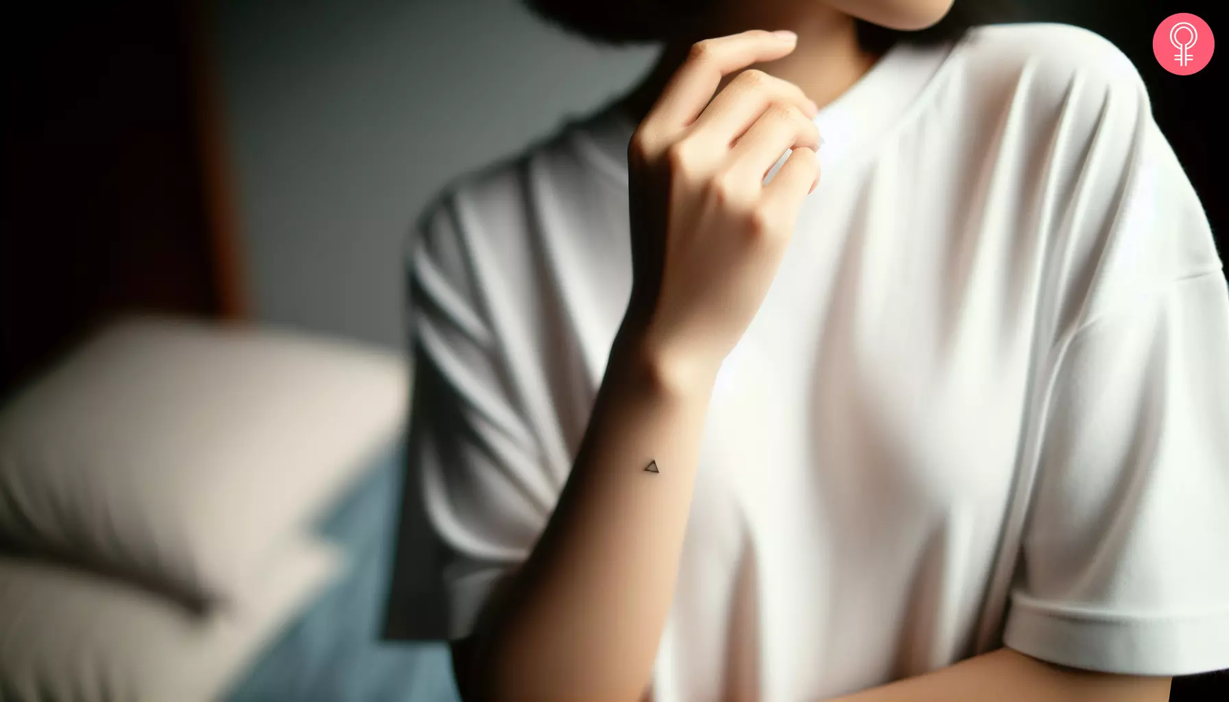 A woman with a tiny triangle tattoo on her forearm