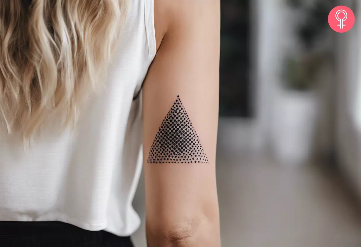 A woman with a triangle dot tattoo on her upper arm