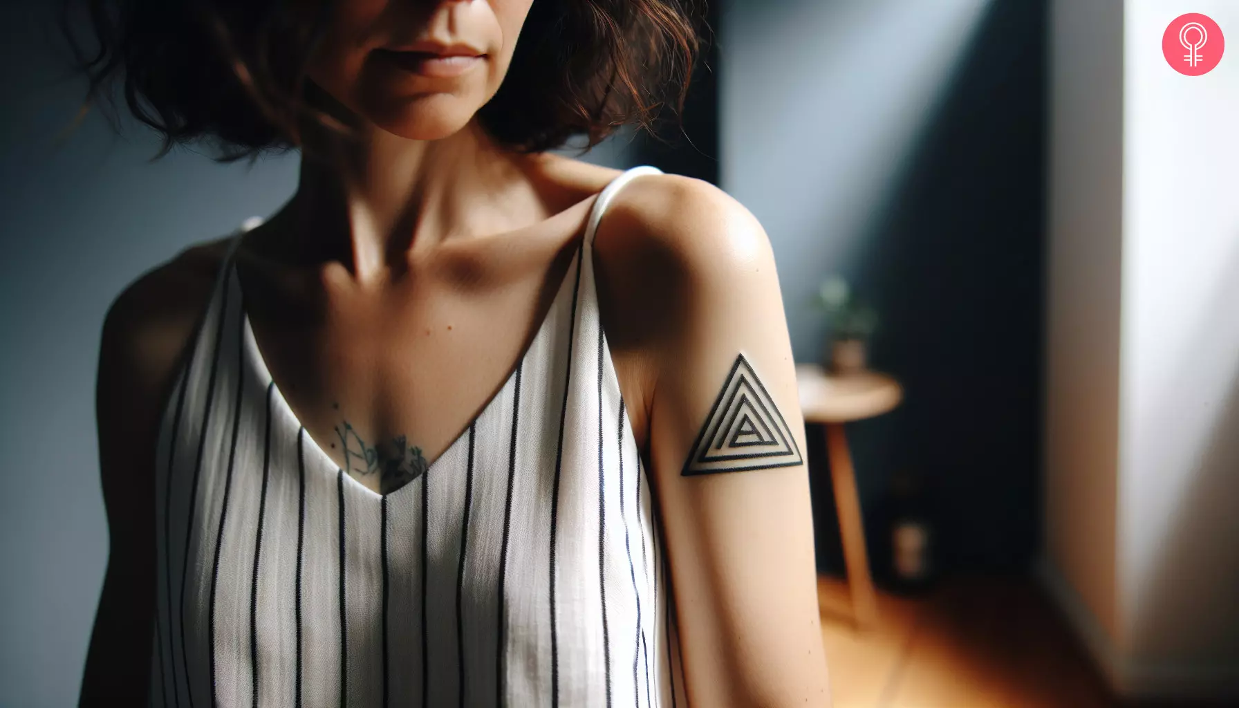 A woman with a tribal triangle tattoo on her upper arm