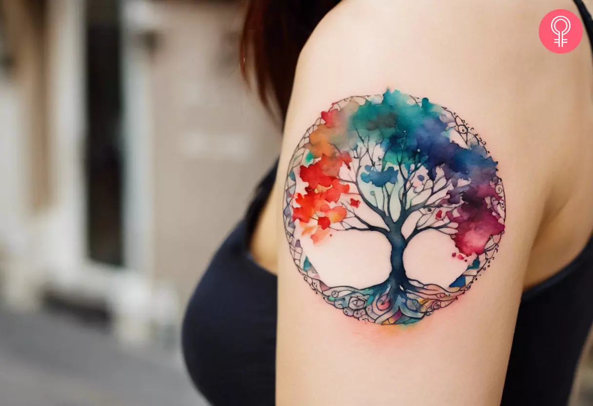 A woman with a watercolor tree of life tattoo on her upper arm