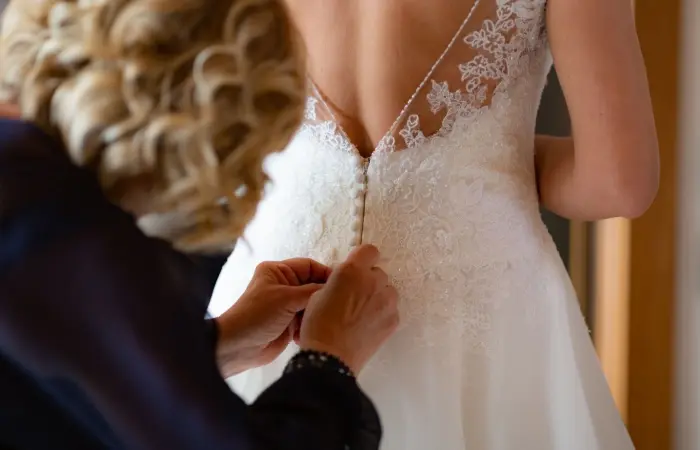 A bridesmaid helping the bride