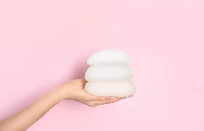 A woman holding silicone breast implants