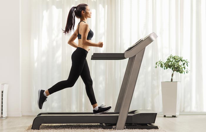 Woman walking on a treadmill to get 10,000 Steps during COVID-19