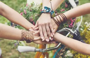 Hands of female friends together in a garden