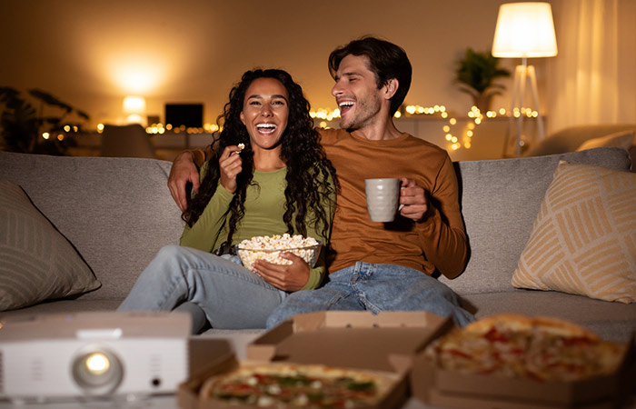Couple watching a funny movie together and laughing