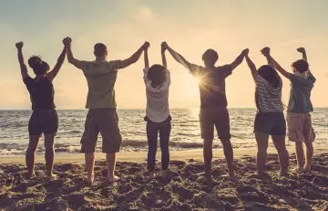 Group of friends in the beach celebrating friendship