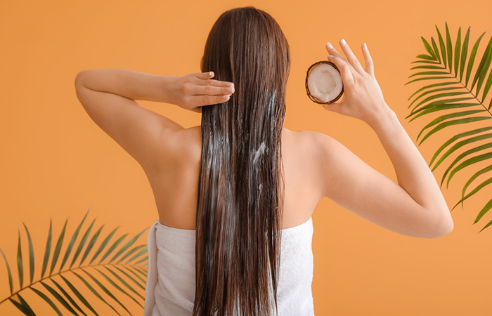 Woman applying coconut oil as a deep conditioner