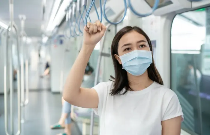 A woman wearing a face mask while traveling