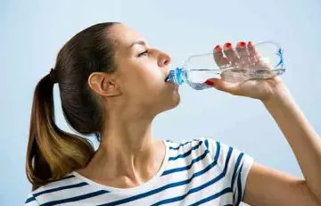 A woman drinking water to lose belly fat