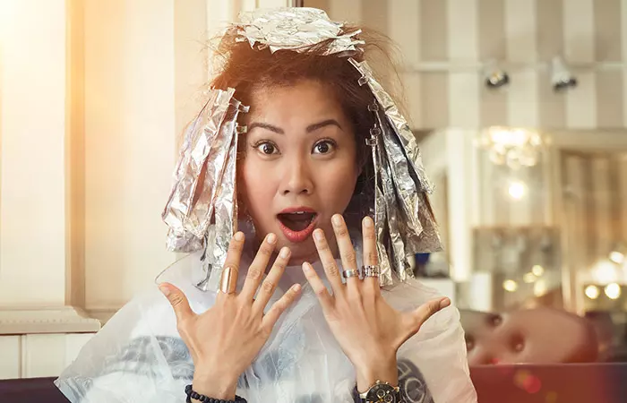 Woman poses as she waits for her bleaching process to work on her dark hair