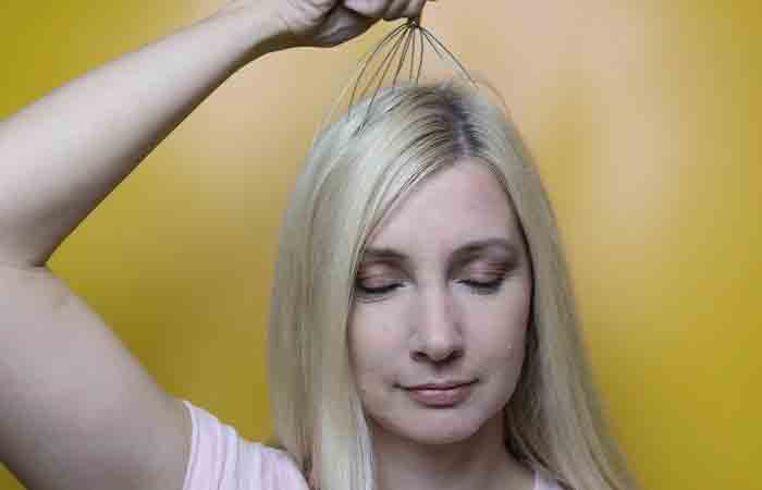 Woman massages her scalp to repair bleach-damaged hair