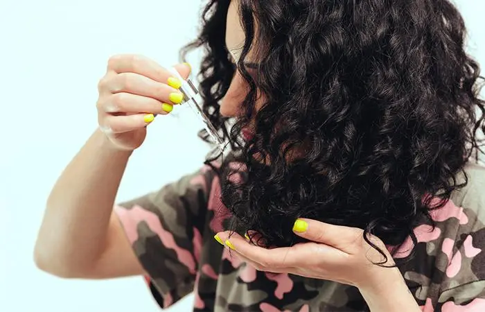 A woman applying nourishing hair oil for her coarse hair