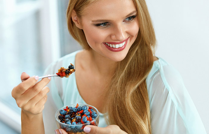 Woman eating berries to prevent hair loss