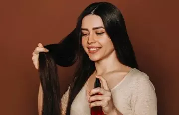 A woman applying a hair conditioner 