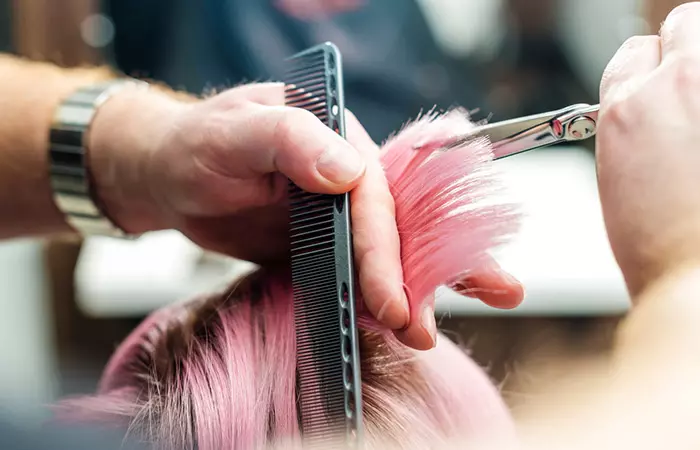 Hairstylist cutting off damaged hair ends 