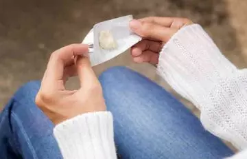Use ice to freeze the gum and remove it. Woman removed chewing gum from her hair.