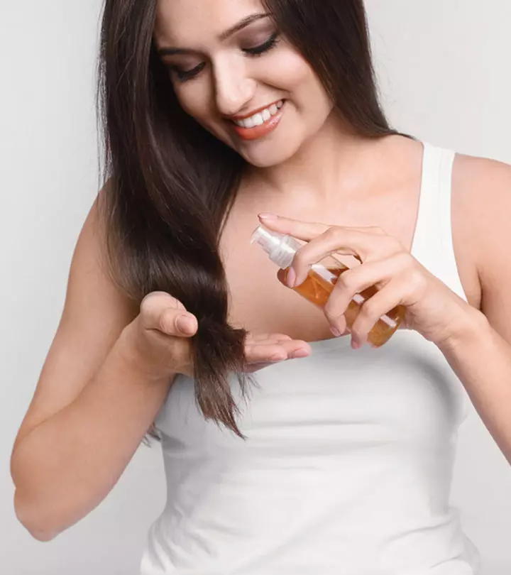 woman applying baby oil on her hair