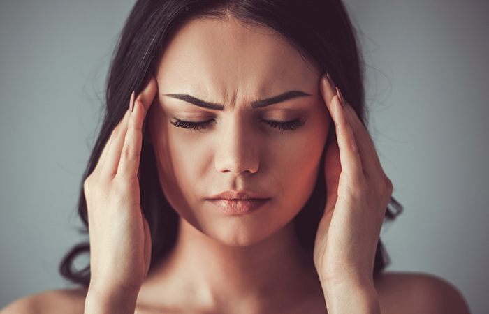 Woman experiencing headache as a side effect of spironolactone