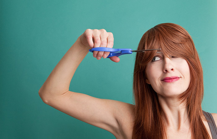 Woman trimming hair to repair crown area hair breakage
