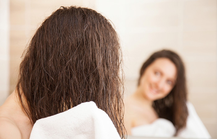 Woman drying her hair after using natural ingredients instead of shampoo