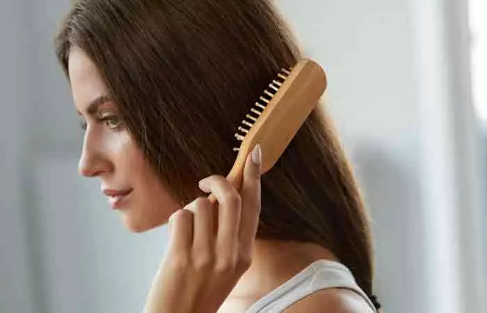 Woman running a hairbrush through her hair