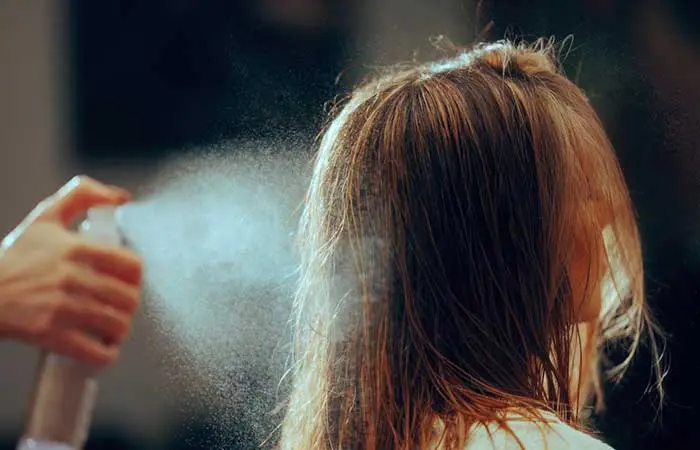 A woman spraying her hair