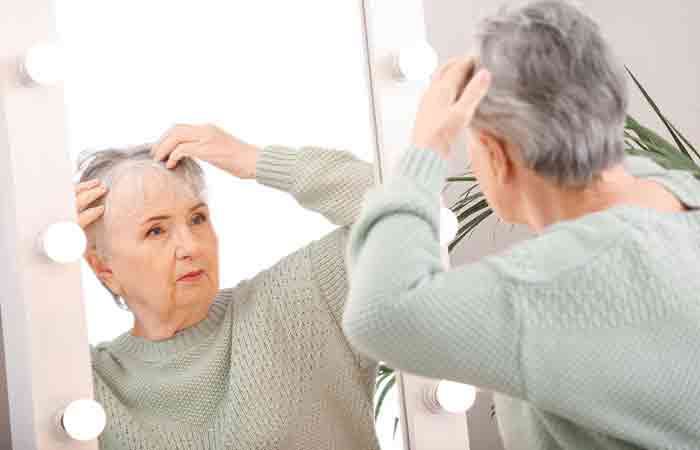 Older woman checking her low hair density