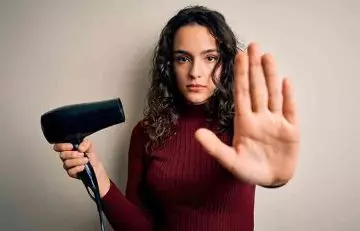 Woman preventing brassy tones from brown hair by stopping use of blow dryer