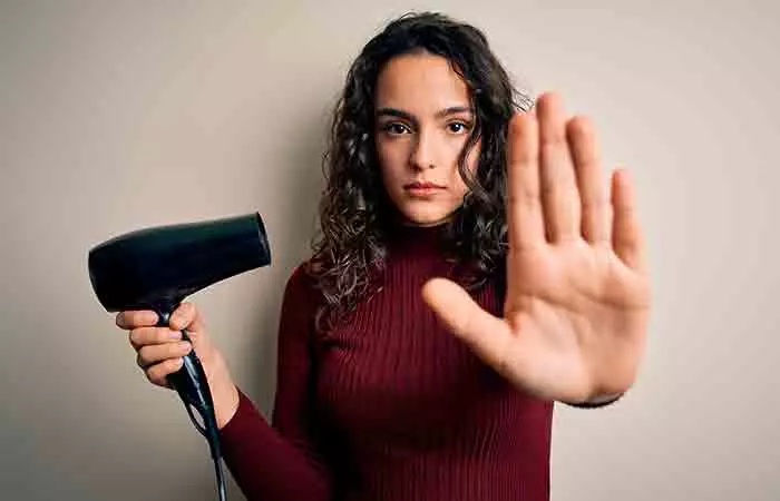 Woman preventing brassy tones from brown hair by stopping use of blow dryer